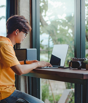 Person Working On Laptop At Window Seat