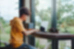 Person Working On Laptop At Window Seat