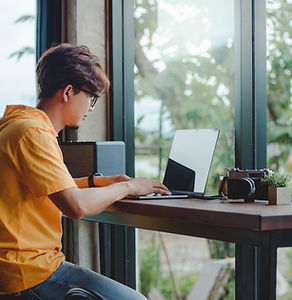 Person Working On Laptop At Window Seat
