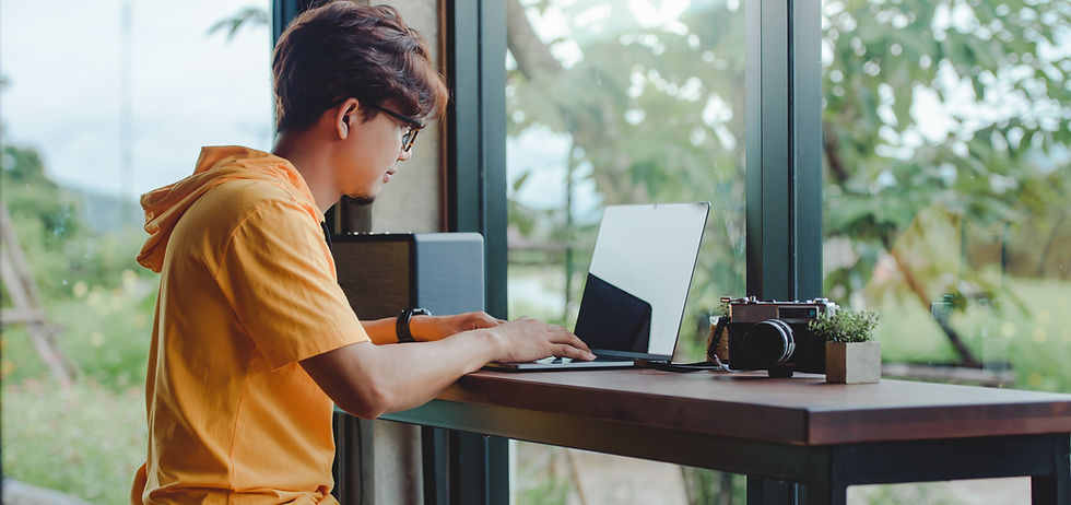 Person Working On Laptop At Window Seat