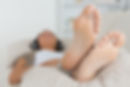 Woman with her feet up listening to music on the sofa