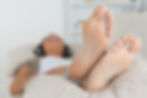 Woman with her feet up listening to music on the sofa
