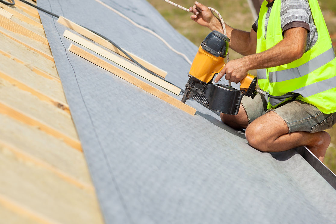 Roofer uses automatic nailgun to attach roofing membrane