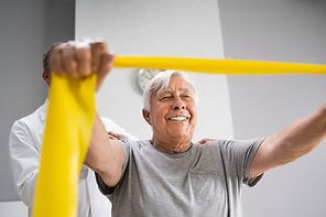 Elderly gentleman holding resistance band in hands