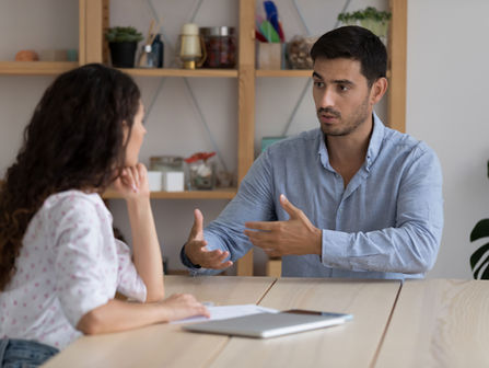 Two people in a serious, direct conversation — representing the difficult moment leaders avoid when they fear being the bad guy, addressed through leadership coaching.