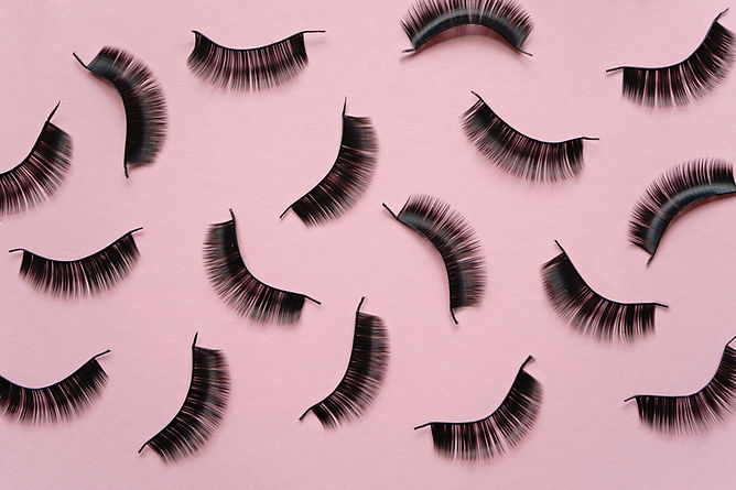 Falsche Wimpern auf einem rosa Hintergrund