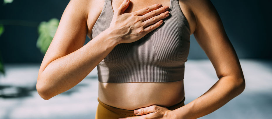 woman with hands on chest and stomach in meditation or gut check