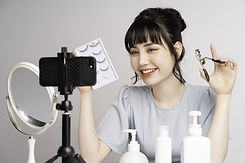 Asian livestreamer applying false eyelashes