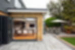 A general interior view of a Home extension with open patio doors, garden furniture table