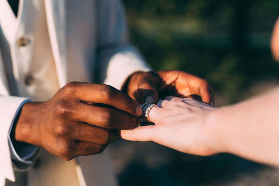 a man is putting a wedding ring on a woman 's finger
