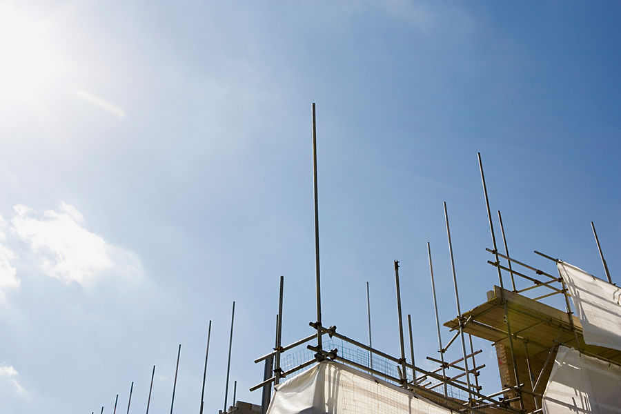 Construction scaffolding illuminating metal poles and white sheeting