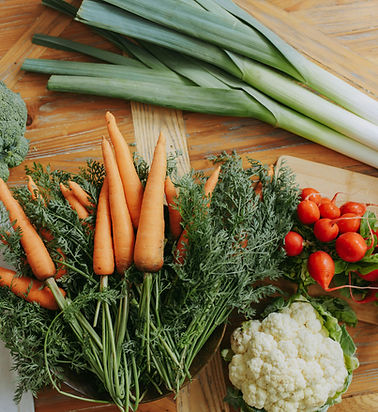 Fresh carrots, leeks, cauliflower and tomatoes laid out for a cooking class