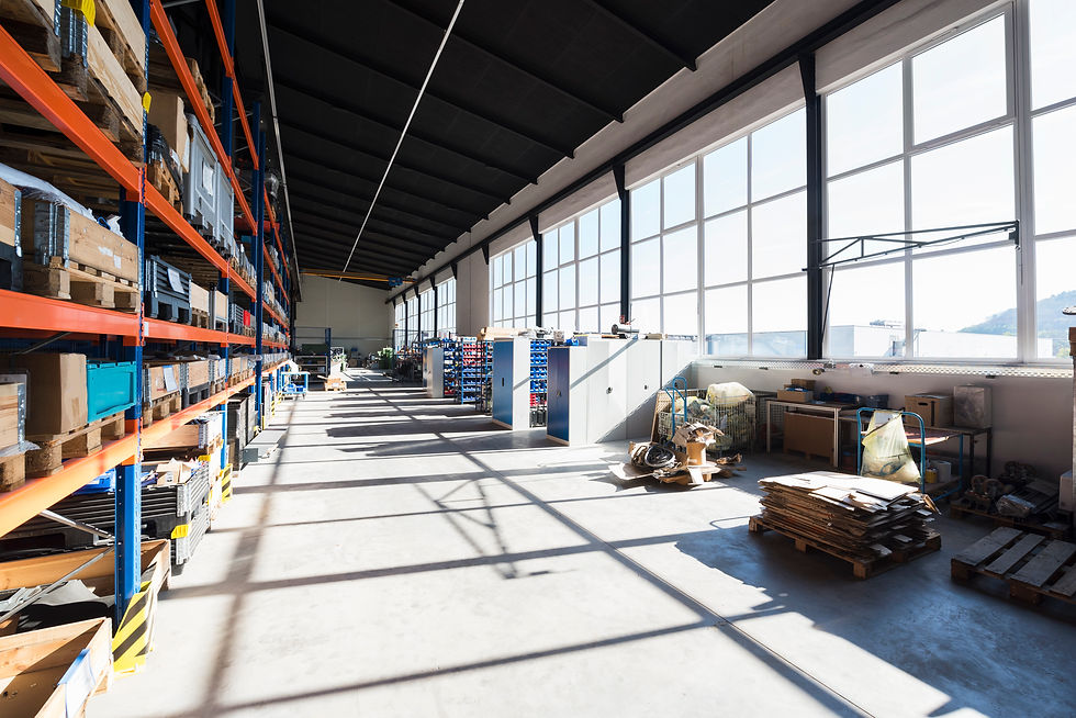 Industrial warehouse shop floor with orange storage shelving racks and large windows