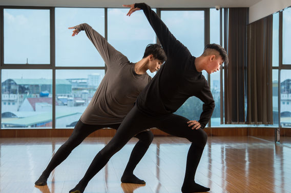 dancers performing partnered lift near windows