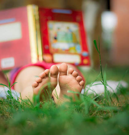 Child Reading in the Grass