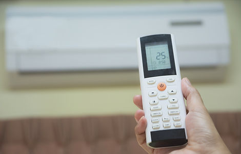 Hand holding remote control for open air conditioner in the room