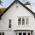 White stucco house with gabled roof and chimneys