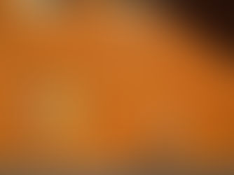 Orange exterior wall with door above ground and someone walking toward