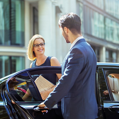 A man and woman are entering a car together, preparing to drive away