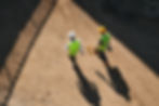 Two people walking on a construction site.