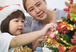クリスマスツリーを飾る母と娘