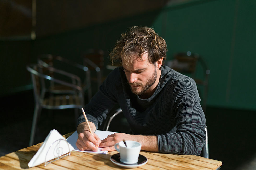 man writing on paper