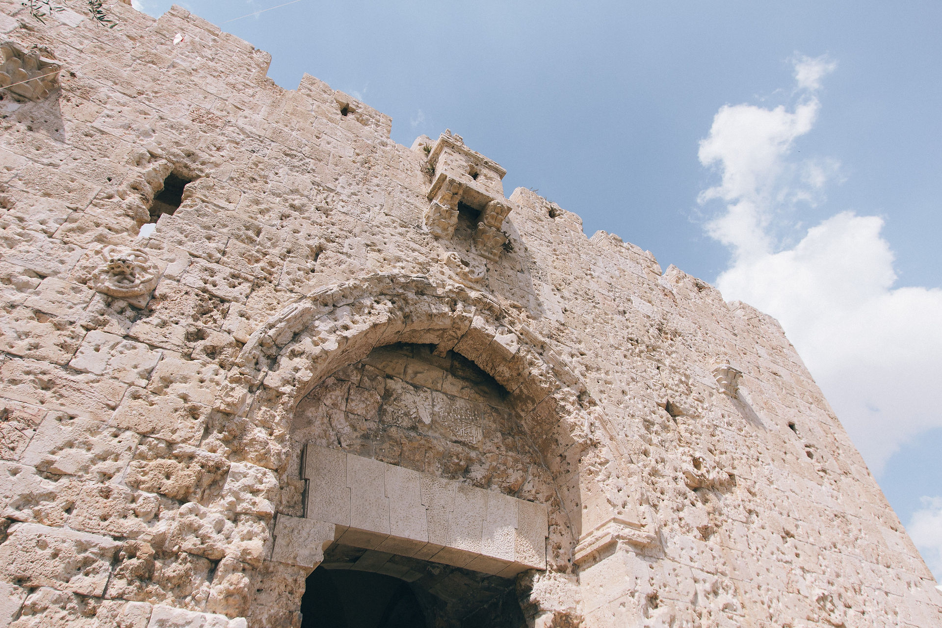 Alt Text: Close-up of the weathered limestone walls of Mount Zion, showing historical carvings and layers of Jerusalem stone.