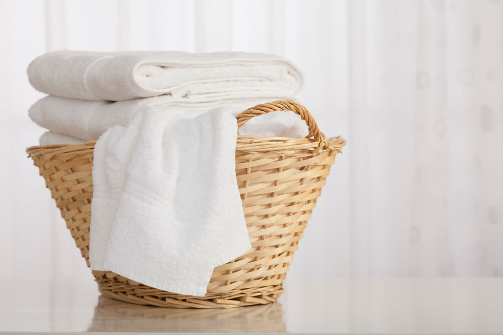 A wicker basket with neatly folded white towels.