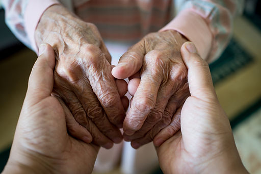 Close up of supportive hands holding to represent compassionate palliative care
