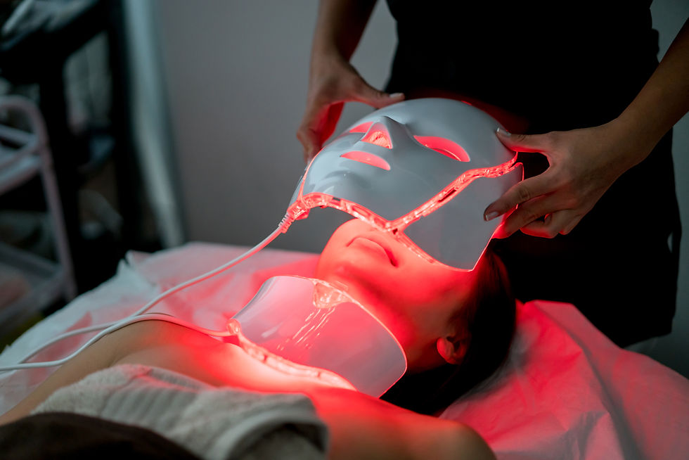 Woman receiving a red light facial treatment at a beauty spa