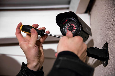 Cropped image of technician installing security camera on wall