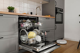 Open dishwasher in a modern kitchen with gray cabinets