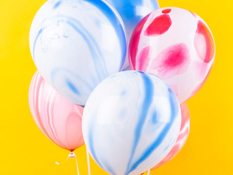 blue and pink balloons against yellow backdrop