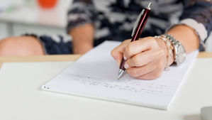 A woman writing on a notepad.