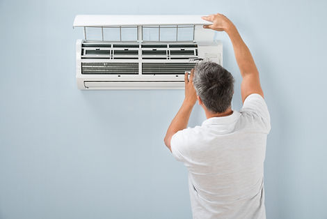 Rear View Of A Man Cleaning Air Conditioning System