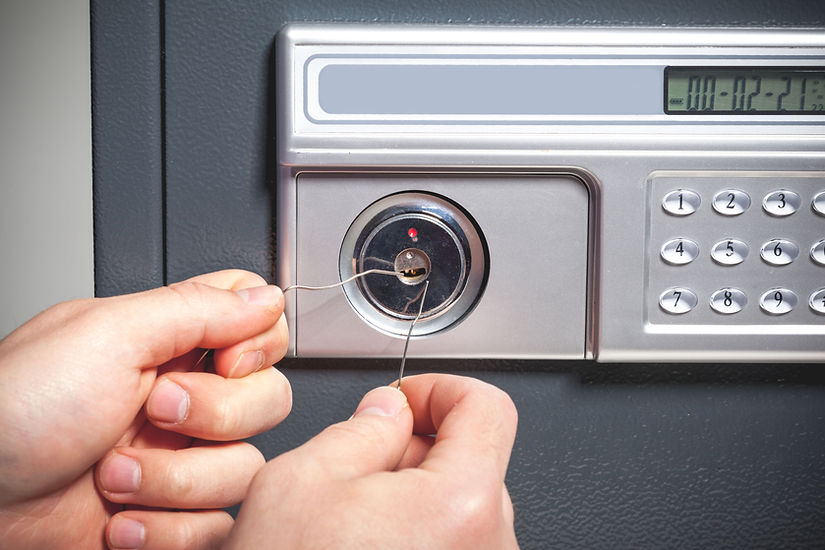 Close-up of hands unlocking a safe with tools