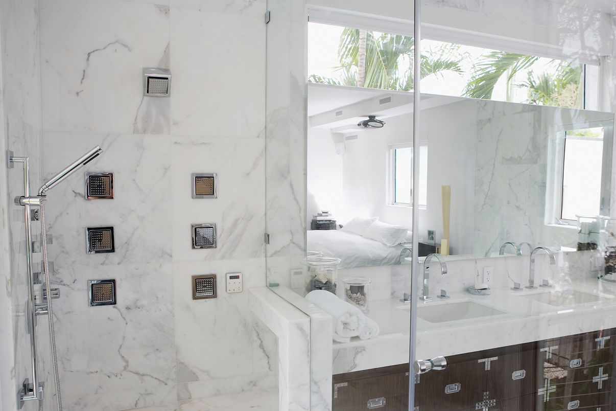 Modern bathroom with marbled design, showing shower and sink