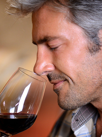 Uomo che sente l'odore del vino