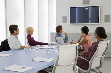 Five people seated around a table in a bright meeting room.