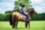 Side view of mature woman and girl horseback riding, looking away