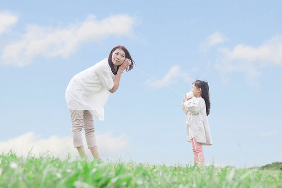 糸電話で遊ぶ母親と子供