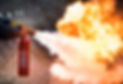 A man using a carbon dioxide fire extinguisher to fight a fire