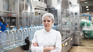 Infographic showing key KPIs in beverage and canning production lines, including throughput, defect rate, downtime, and energy efficiency, with visuals of automated machine vision systems inspecting bottles and cans on a production line.