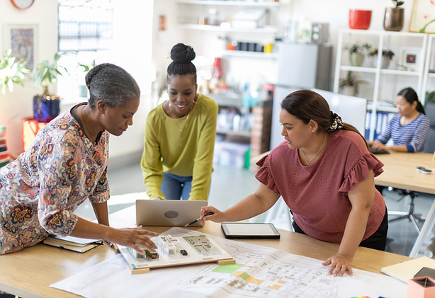 Three women business owners standing proudly in their storefront