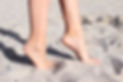Sideways view of legs of young girl walking on tiptoe on the sand in Mondello Beach, Sicil
