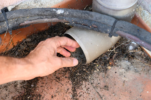 Man´s hand unclogging downpipe of a gutter