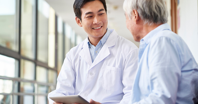 A doctor speaks to his patient while using AvoMD on his tablet
