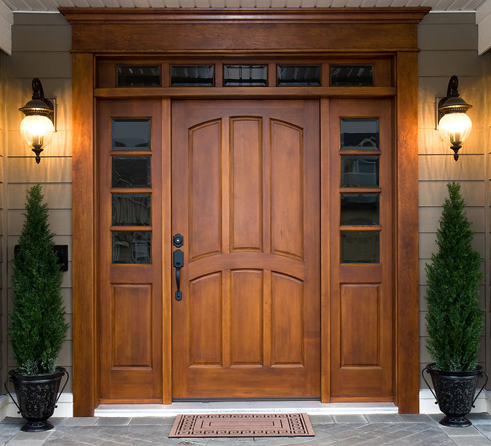 Large bespoke wooden front door with glass panels.