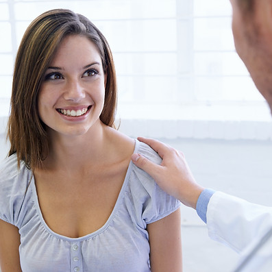 A young woman being reassured by her doctor during a consultation