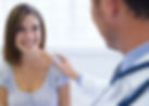 A young woman being reassured by her doctor during a consultation